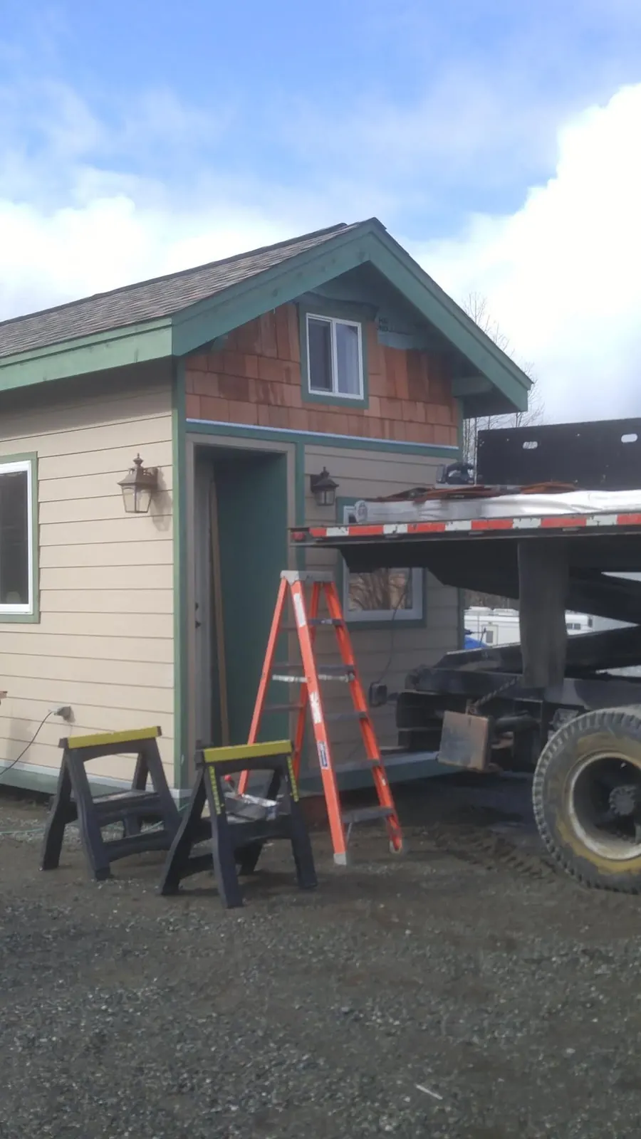 A small building with cedar-shingle gable and green trim, on a Frontier job