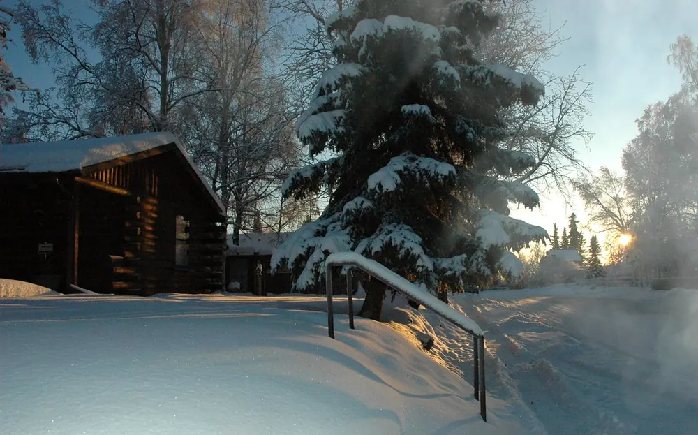 A log cabin in Anchorage under deep snow